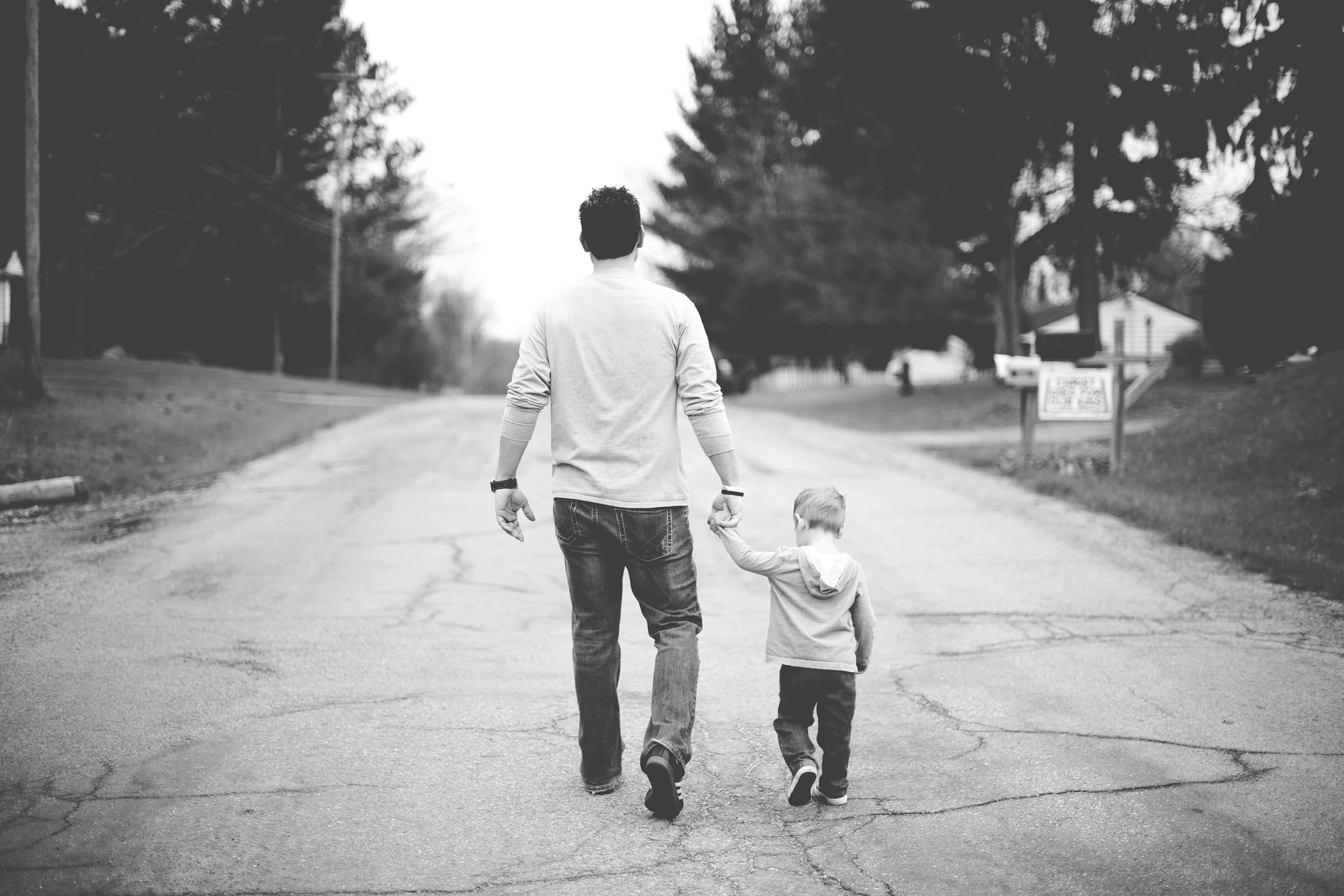 Father walking and holding his infant son&#x27;s hand