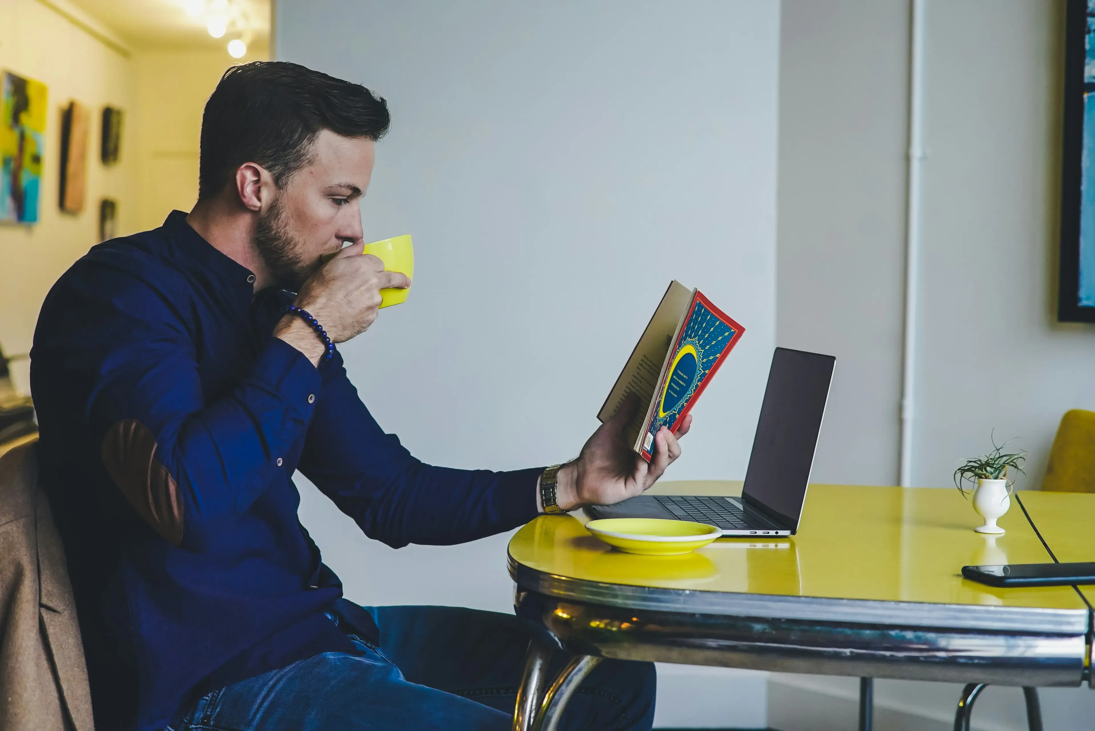 Man reading a book and drinking coffee